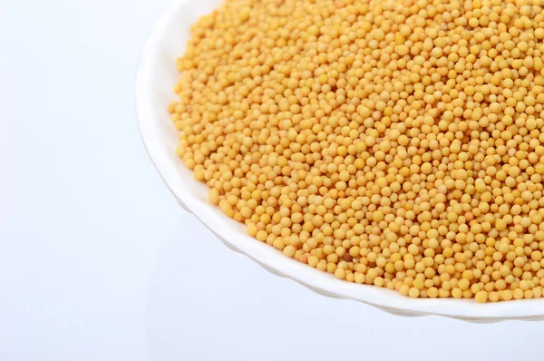 Yellow mustard seeds in plate — Stock Photo, Image