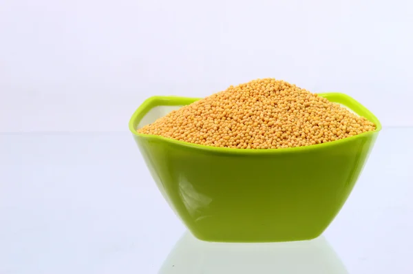 Семена жёлтой горчицы в зелёной чаше — стоковое фото