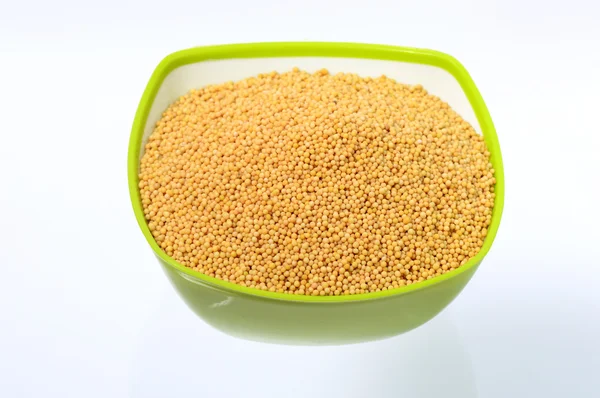 Yellow mustard seeds in green bowl — Stock Photo, Image