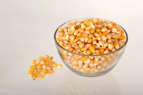 Dried corn in bowl with heap — Stock Photo, Image