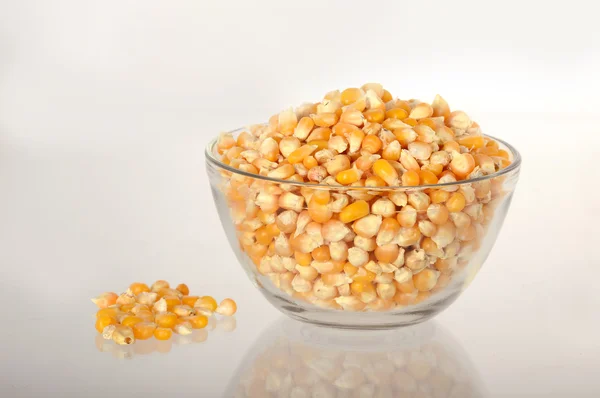 Dried corn in bowl with heap — Stock Photo, Image