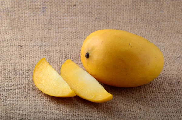 Fruta de mango en tela de saco con rebanada — Foto de Stock