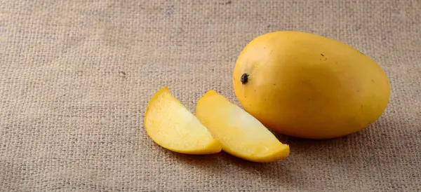 Fruta de mango en tela de saco con rebanada —  Fotos de Stock