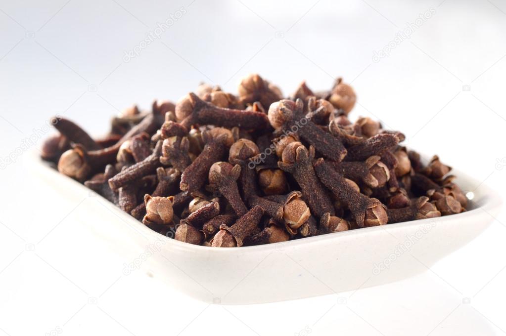 Cloves in plate isolated on white background