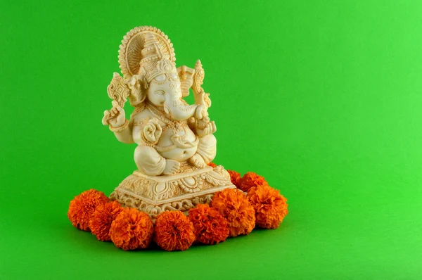 Hindu God Ganesha. Ganesha Idol on Green Background with flowers. — Stock Photo, Image