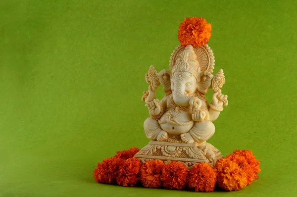 ヒンドゥー教の神ガネーシャ。花と緑の背景のガネーシャ アイドル. — ストック写真