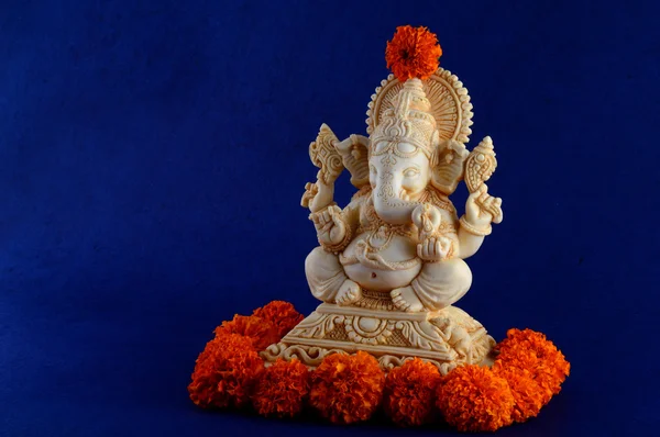 Deus Hindu Ganesha. Ganesha Idol em fundo azul com flores . — Fotografia de Stock