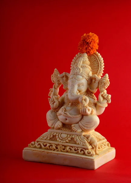 ヒンドゥー教の神ガネーシャ。花で赤背景にガネーシャ アイドル. — ストック写真
