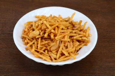 Geleneksel Indiantraditional Hint derin kızarmış falahari chivda-chivda veya karışım beyaz tabak içinde. Indian aperatifler derin kızarmış falahari chivda-chivda veya karışım beyaz tabak içinde. Indian aperatifler
