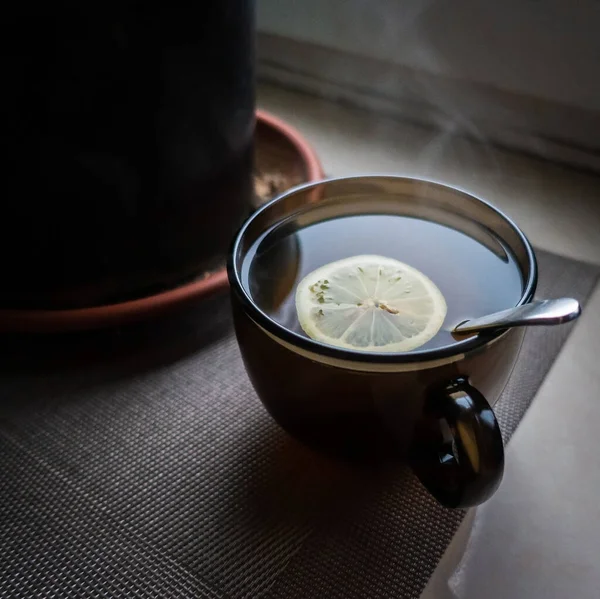 A cup of tea with lemon on the window on a Moscow winter day.