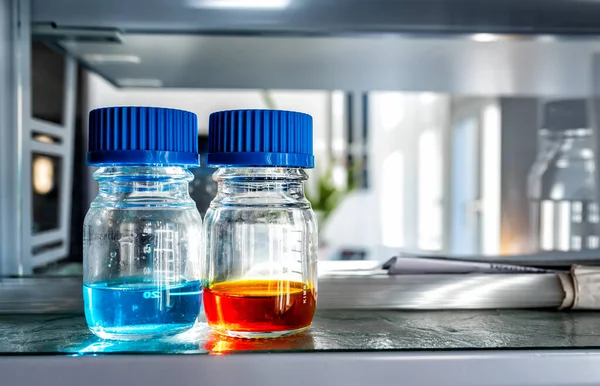 Close Van Laboratoriumglaswerk Gevuld Met Blauwe Oranje Vloeistoffen Wetenschappelijke Onderzoeksachtergrond — Stockfoto