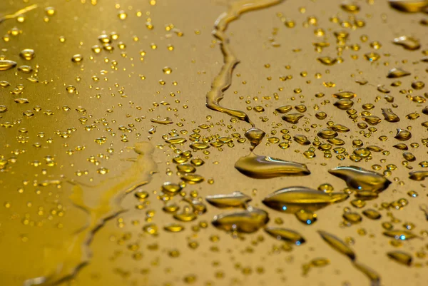 Waterdruppels op de plaat van goud — Stockfoto