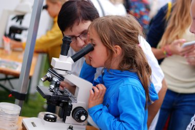 An Unidentified Girl Looks through the Microscope