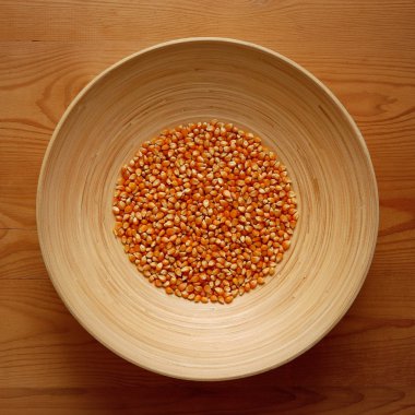 Ahşap arka plan üzerinde Mısır tatlı ile bambu kase