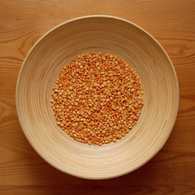 Ahşap zemin üzerine sarı bezelye ile bambu kase