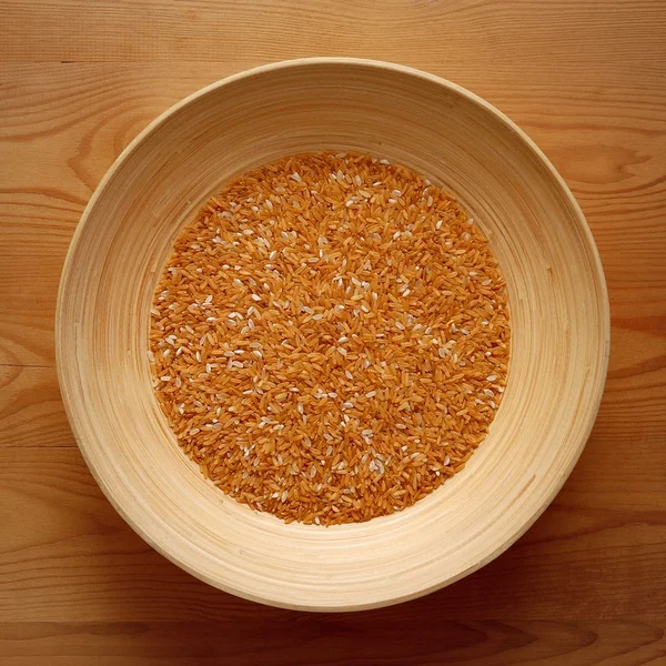 Bambu skål med gult ris på trä bakgrund — Stockfoto