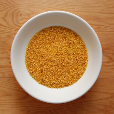 Ahşap masa üzerinde Bulgur ile beyaz kase