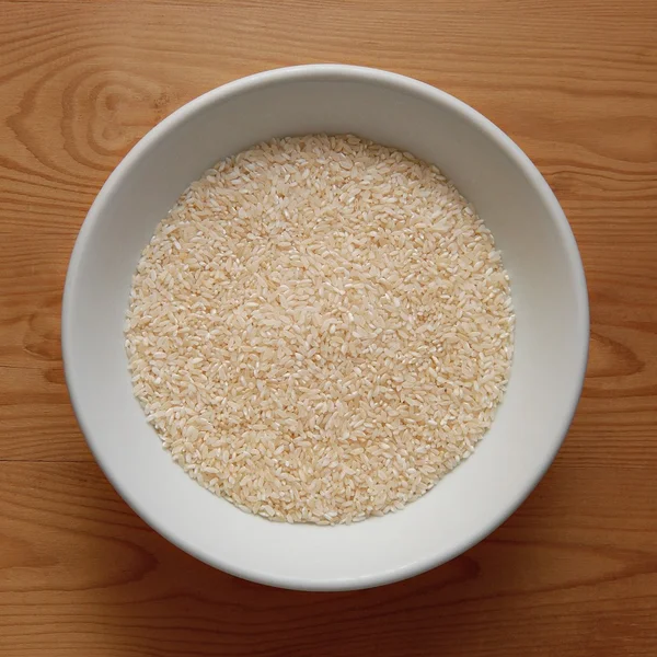 Cuenco blanco con arroz blanco en escritorio de madera —  Fotos de Stock