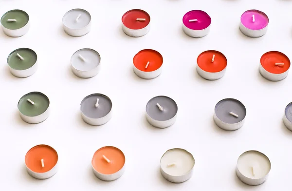 Чайные свечи устроены на рядах на белом столе — стоковое фото