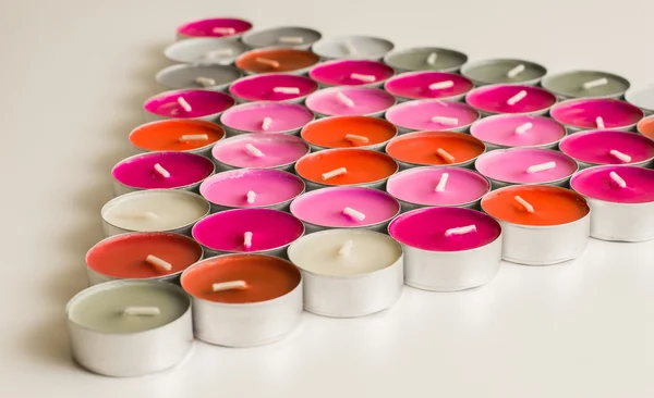 Bougies de thé colorées disposées en forme de triangle, diverses couleurs de bougies — Photo