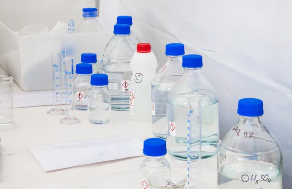 Glazen flessen met blauwe Caps met chemicaliën — Stockfoto