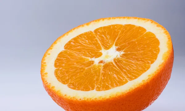 Нарізаний апельсин на світло-сірому тлі — стокове фото