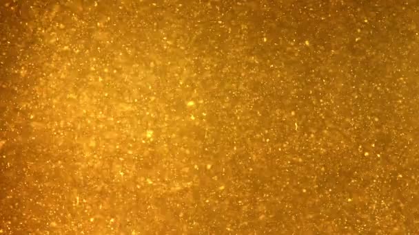 Particelle luminose che scorrono nel liquido giallo scuro — Video Stock