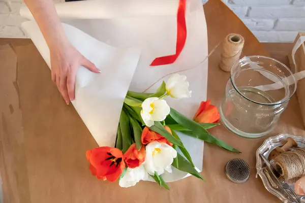 Vrouw Verpakt Een Boeket Rode Witte Tulpen Wit Papier Bloemist — Stockfoto