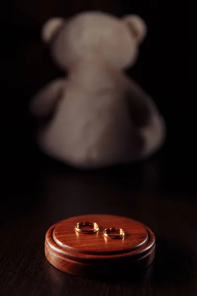Divorce and separation concept. Rings close-up and teddy bear as symbol of child. Family law — Stock Photo, Image