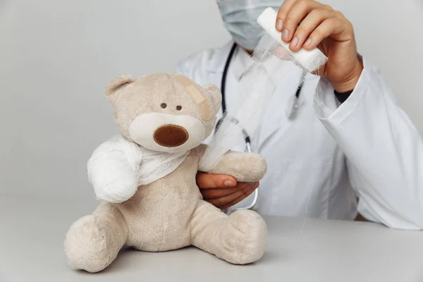 Kinderarts in maskerverband teddybeer in medisch kantoor. Begrip kindergezondheidszorg — Stockfoto