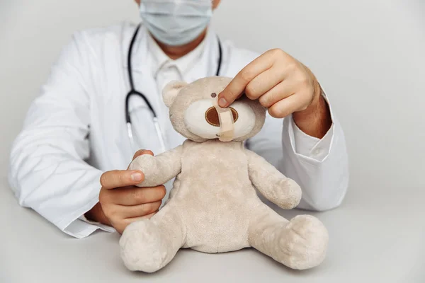 Kinderarts in eigen kantoor behandelt teddybeer. Concept voor kindergezondheidszorg en -behandeling — Stockfoto