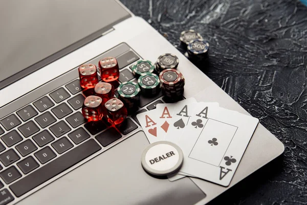 Chips, röda tärningar och spelkort på laptop för poker online eller kasinospel närbild. Online casino koncept — Stockfoto