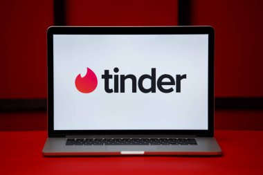 Laptop ekranındaki Tula 06.02.2020 Tinder logosu kırmızı arkaplanda izole edildi.