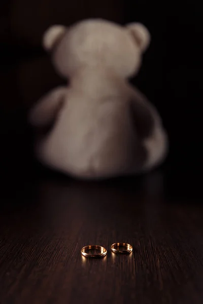 Divorce and separation concept. Rings and teddy bear as symbol of child. Family law