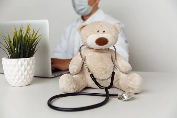 Teddy Bear dengan stetoskop di meja dokter anak. Konsep layanan kesehatan anak Stok Gambar Bebas Royalti