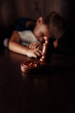 Boşanma kavramı. Tahta tokmak, yüzükler ve oyuncak ayıyla hayal kırıklığına uğramış küçük çocuk. Çocuklar üzerinde aile boşanması etkisi