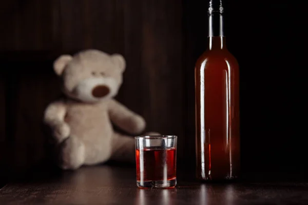 아동 학대 개념. 테디는 나무 탁자 위에 놓인 냉기 안전과 유리병을 상징하는 곰이다 — 스톡 사진