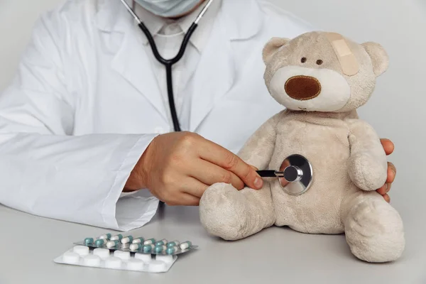 Dokter memeriksa detak jantung boneka beruang di rumah sakit. Konsep Pediatris Stok Foto Bebas Royalti