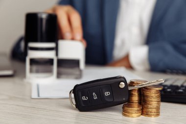 Siyah araba anahtarı ve imzalı bir araba satışı sözleşmesi.