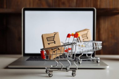 Laptop klavyesindeki trollerde kutular. İş, ecommerce ve alışveriş kavramı