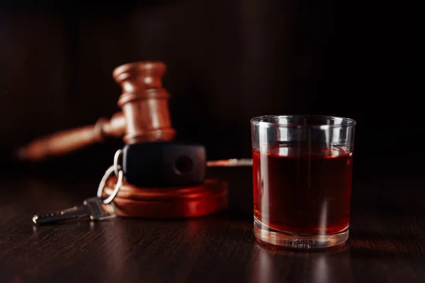 車のキー、木製の裁判官のギャベルとガラスのクローズアップとアルコールのボトル。飲酒運転の概念 — ストック写真