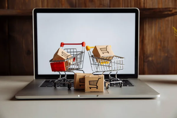 Cajas en un carro en un teclado portátil. Concepto de compras online — Foto de Stock