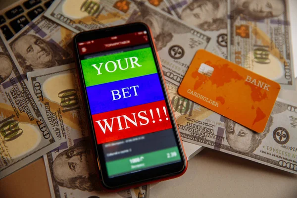 ギャンブルモバイルアプリケーションとドル紙幣のデビットカードを持つスマートフォン — ストック写真