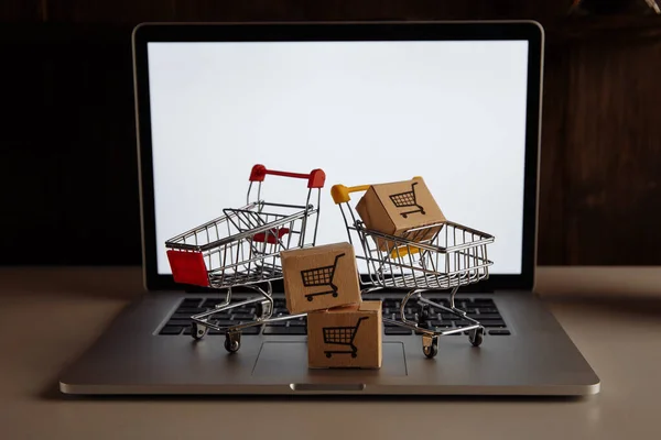 Cajas en carros de supermercado en un teclado portátil — Foto de Stock