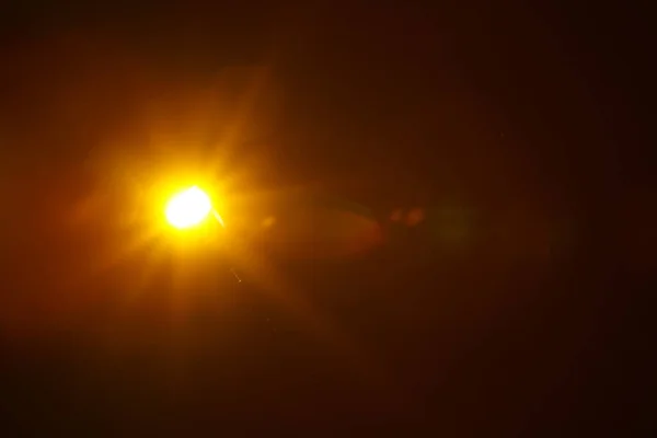 Abstract Natuurlijke zonnevlam op de zwarte achtergrond. — Stockfoto