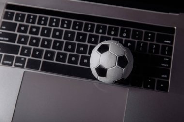 Dizüstü bilgisayarda futbol topu. Spor, kumar, para kazanma konsepti