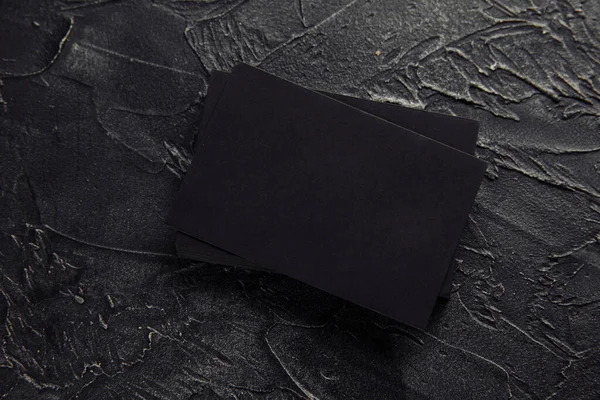 Stack of black envelopes on a dark table