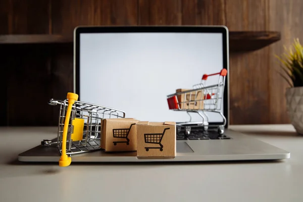 Papierboxen im Einkaufswagen auf einer Laptop-Tastatur. Online-Shopping und Lieferkonzept — Stockfoto
