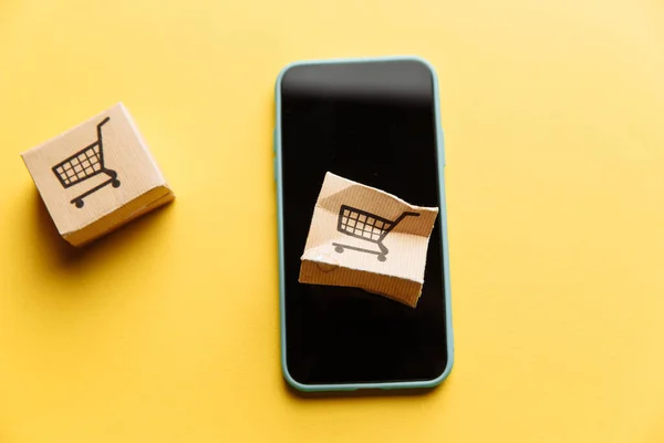 Caja de papel dañada en un primer plano de pantalla de teléfonos inteligentes. Compras en línea, servicio y concepto de entrega —  Fotos de Stock