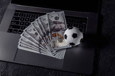 Bahisler, spor bahisleri, bahisçiler. Dizüstü bilgisayarda futbol topu.